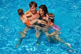 Happy Family With Kids In Swimming Pool Smiling Parents And Children On Summer Vacation Pool Swimming Pools Swimming