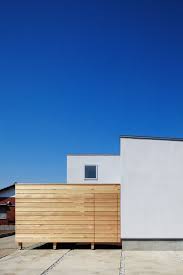 モルタル下地吹付塗装の継ぎ目のない外壁とレッドシダーの目隠し塀 テラスのデザイン 塀 住宅 外観