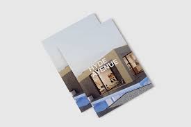 The book is placed on a table to showcase how it stands out with other items and stationery. Magazine Mockup Free Mockup Download