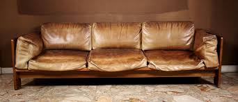 Rolled arms and turned bun feet in solid wood make this a timeless style that's just right for the relaxed traditional living room. Lot Art Low Sofa In Natural Wood With Used Brown Leather Cushions