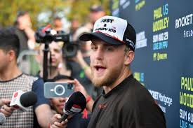 Jake paul, left, speaks at the final press conference as tyron woodley, wearing sunglasses, listens.+ in silence. H0gjxaixyh9num