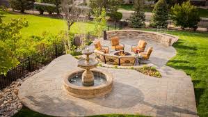The gentle sound of the falling water with the warm glow from the fire makes this a customer favorite. Serene Stone Patio With Water Feature And Fire Pit Elite Landscape Outdoor Living Hgtv