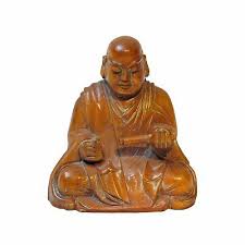 Buddha statue on a table. Buddha Carved Wood Buddha Statue