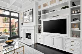Chic White Living Room Features A Built In Flat Panel Television Fixed Above White Cabinets Adornin Built In Tv Cabinet Living Room Built Ins Built In Cabinets