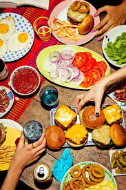 A Group Of People Sitting At A Table With A Plate Of Food Food Photography