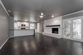 Grey is a color that looks relaxed, subtle, trendy, and even versatile. Modern Living Room Dark Wood Floor Floating Fireplace Mantel White Brick Waterfa Dark Wood Floors Living Room Living Room Wood Floor Grey Walls Living Room