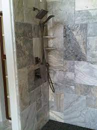 Done in simplistic river rock cement accented by the smooth profiles of the matte black telephone shower. Silver Travertine In The Shower Travertine Tile Bathroom Tile Bathroom Bathtub Decor