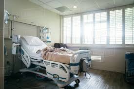 Empty hospital bed near sunny window - Stock Photo - Dissolve