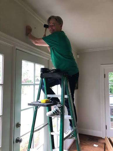 Fitter measuring window frame height for curtain rod brackets