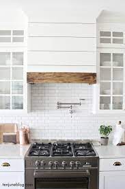 These muted colors really make the bright stainless steel range hood pop. Ten June Farmhouse Shiplap Kitchen Vent Hood