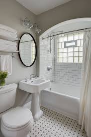 Crown molding is placed below the ceiling line, which draws attention upwards, and adds beautiful pops of orange come through clean white fixtures and gray walls. Small Gray Bathroom Ideas A Balance Between Style And Space Conscious Design