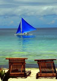 Rest In Blue A Blue Sailed Banca Passing By A Serene Seaside In Bora Bora Sailing Boracay Philippines Beautiful Beaches