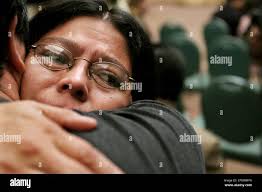 Irene Barrientos is comforted by a friend during a ceremony in which the  Government of Guatemala apologized officially for the kidnapping and  killing of 11 student leaders of the University of San
