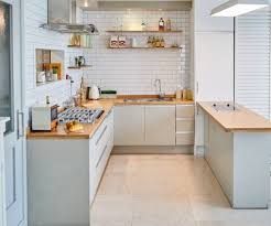An Open U Shaped Kitchen Design With Cabinets Replaced By Shelves Against White Bricks Mid C Open Kitchen Interior Modern Kitchen Design Kitchen Design Open