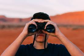 Sailor man looking through the binoculars against blue sky background. Man Looking Through Binoculars Pikrepo