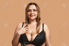 Chubby Pretty Woman In Sexy Black Lingerie Looking At Camera And Smiling  While Standing Against Brown Background In Studio Stock Photo, Picture and  Royalty Free Image. Image 126787473.