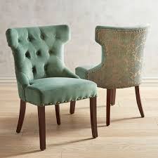 elegant hourglass chair in rich green with hand placed button tufts deep comfortable padding nailhead tr dining chairs luxury dining room green dining chairs