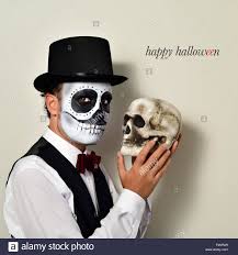 Der mexikanische tag der toten ist auch bei uns mittlerweile beliebt zu halloween. Ein Mann Mit Mexikanischen Calaveras Make Up Mit Fliege Und Zylinder Mit Einem Schadel In Der Hand Und Der Text Happy Halloween Stockfotografie Alamy
