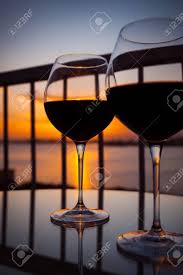 L'aspetto lussuosamente elegante dei bicchieri esalta l'anticipazione del piacere del vino e aggiunge una. Immagini Stock Due Bicchieri Di Vino Rosso Di Fronte Al Tramonto Vista Del Balcone Con La Priorita Bassa Del Mare Caraibico Image 67779435