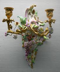 Scrolled iron above and below the clear glass flank diamond details directing the eye to the center where a white or colored pillar candle. Sconce Light Fixture Wikipedia
