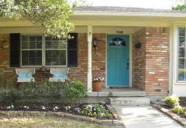 A picture from last year of us standing in front of the black door. Turquoise Door With Black Shutters And Pinkish Brick Painted Front Doors House Front Door Best Front Door Colors