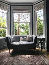 Blinds give a bay window a clean appearance while still adding color and texture. Dark Living Room Dark Living Rooms Roman Blinds Living Room Bay Window Living Room