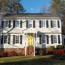 The exterior face lift included hardie board siding and miratec trim, decorative metal railing on the porch, landscaping and a custom mailbox. White House Navy Shutters Yellow Front Door What Color Shutters Would Look Best With White Vi House Shutters House Doors Colors Yellow Front Door White House