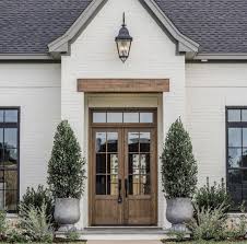 Black And White House With Wood Door Pin By Brighton Guenther On Exteriors White Exterior Houses Brick Exterior House Painted Brick House