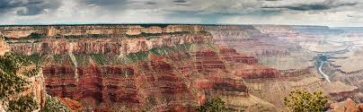 Beautiful panoramic panning timelapse looking over the grand canyon south rim as the sun rises over the horizon bringing light onto the snow covered red rock cliffs. Grand Canyon Panoramic By Bradwetli Photography