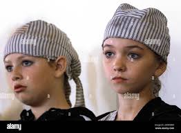 Student dancers, Calleigh Sherell, right, and Addison Campbell, left,  listen to a Holocaust survivor speak before performing "Yeladim-Yeshaynim,"  hebrew for "Sleeping Children", a tribute to victims of the Holocaust, as  part of