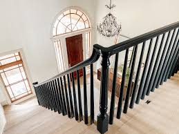 Stair case with black painted handrail and newell post and also stair risers painted black. How We Completely Updated Our Stair Railings By Only Swapping Out The Balusters Chris Loves Julia