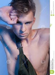 Male in coveralls with his fist near face - male-coveralls-his-fist-near-face-young-handsome-man-attractive-fashionable-hairstyle-dressed-dark-green-looking-33489107