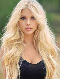 Beautiful model with long smooth, flying blonde hair isolated on dark grey studio background. 11 Best Leave In Conditioners For Silky Strands Most Beautiful Faces Blonde Beauty Lovely Eyes