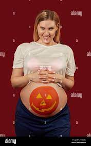young pregnant woman with pumpkin halloween painted on her stomach Stock  Photo - Alamy