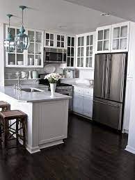 The backsplash made of white wood and white kitchen cabinets looks gorgeous with a dark wood floor and black hardware. 40 Dark Hardwood Floors That Bring Life To All Kinds Of Rooms