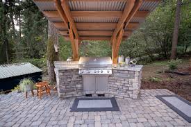 This outdoor kitchen unit is made up of an elegant pergola and a large work island. Outdoor Grill Islands Paradise Restored Landscaping