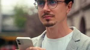 Serious confused Indian ethnic business man using mobile phone map  navigation application online lost in city smartphone app internet location  choosing looking around guy businessman male at street