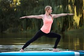 Yoga On A Paddle Board Brings A Brand New Angle To Exercise Fitness Trends Paddle Board Yoga Fitness