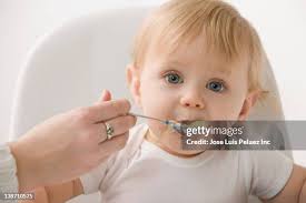 Baby Eating Porridge High-Res Stock Photo