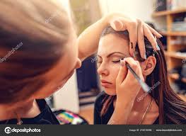 makeup artist applying eyeliner model