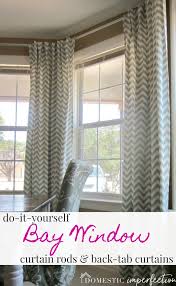 If you want total blockage of light and insulation from the outdoor elements, hang the heavy, blackout type curtain panels. Diy Bay Window Curtain Rod Back Tab Curtains Domestic Imperfection
