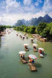 The yulong river scenic area bike route winds in an out of quaint villages and picturesque farmland, all the while being totally encompassed by stunning karst formations. Bamboo Rafting Along Yulong River In Guilin You Will Not Only See The Essence Of The Beautiful Natural View You Could Also Find River Rafting River Rafting