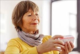 Woman carefully reading a medicine bottle label at home before taking a dose