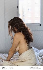 Sexy tätowierte Frau mit schönen langen Haaren sitzt auf dem Bett - ein  lizenzfreies Stock Foto von Photocase