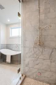Removing the former wall between the kitchen and dining room to create an open floor plan meant the former powder room tucked in a corner needed to be relocated. Mixed Gray Marble Shower Tiles With Marble Chair Rail Tiles Transitional Bathroom