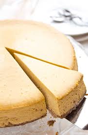 Pumpkin squares on a white plate with a pumpkin and white mug in the background. Low Carb Pumpkin Cheesecake Sugar Free Londoner