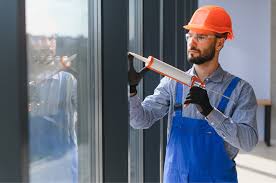Technician inspecting air sealing around a commercial window installation.