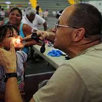 Hospitalman Michael Buertey visits with children during a community service  medical event at the Barranca Municipal Gym medical site in Barranca, Costa  Rica,