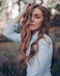 Close up portrait of beautiful charming young woman with brown hair and blue eyes and freckles standing near turquoise fence smiling turning head. What Is The Best Hair Color For Freckles Hair Adviser