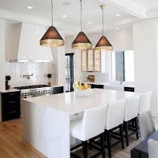 Three Black And Gold Light Pendants Illuminate A Calcutta Quartz Waterfall Countertop Accent Kitchen Decor Apartment Kitchen Island Quartz White Kitchen Design